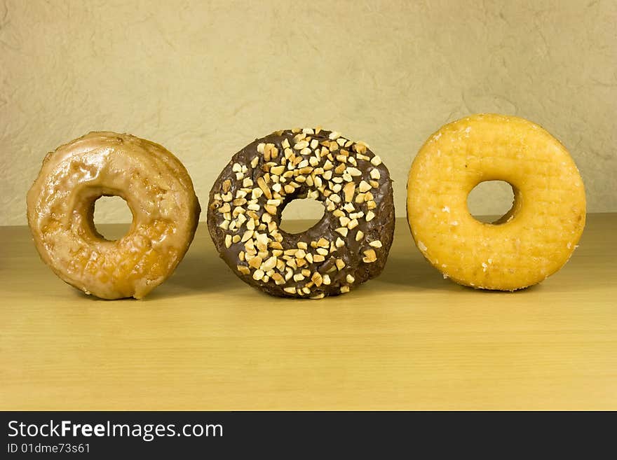 Three fresh donuts on surface