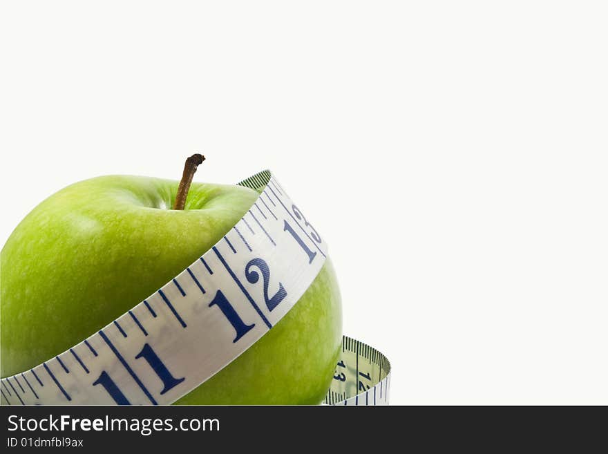 Green apple wrapped by a measuring tape