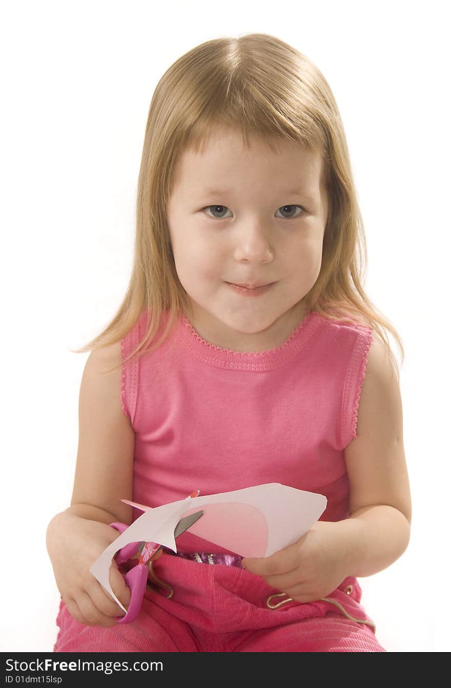 Pretty small girl is cutting paper heart shape