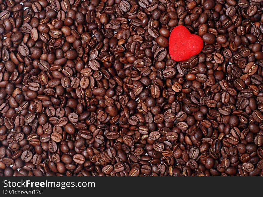 Red heart in the heap of brown coffee beans. Red heart in the heap of brown coffee beans