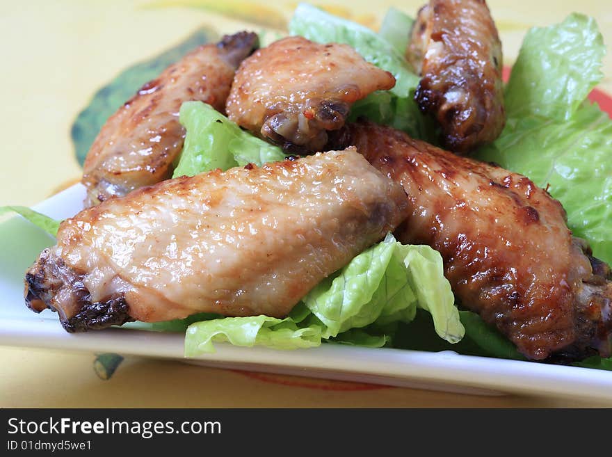 Grilled chicken wings with hot pepper sauce and salad