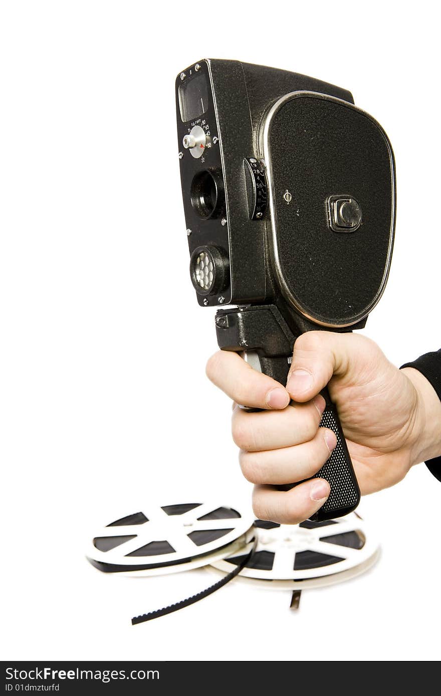 Man hand with old movie camera and two reels of film on background