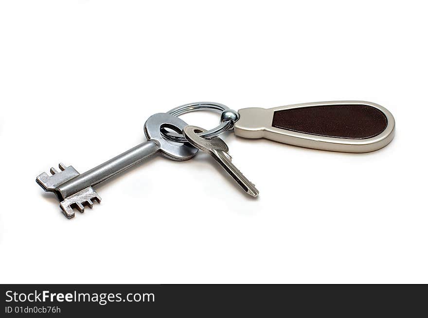 Two keys on a charm. It is isolated on a white background. Two keys on a charm. It is isolated on a white background