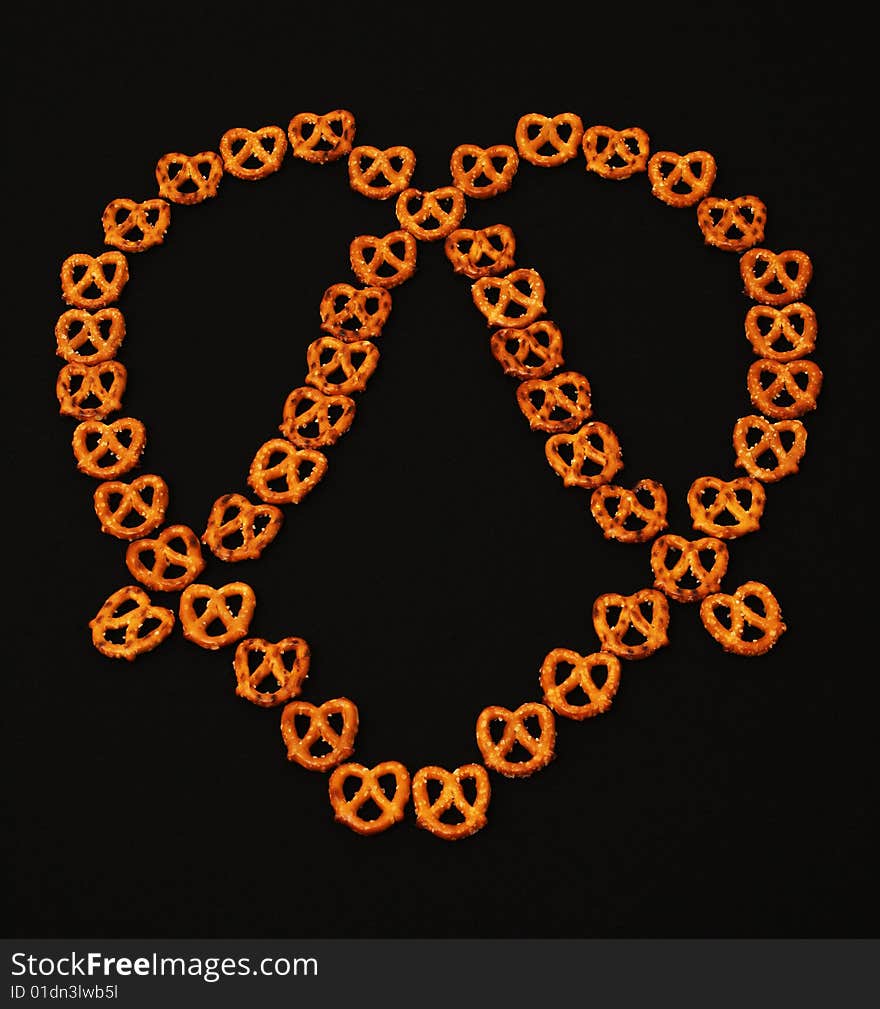 Many small pretzels arranged to make the illusion of a bigger one. Many small pretzels arranged to make the illusion of a bigger one.