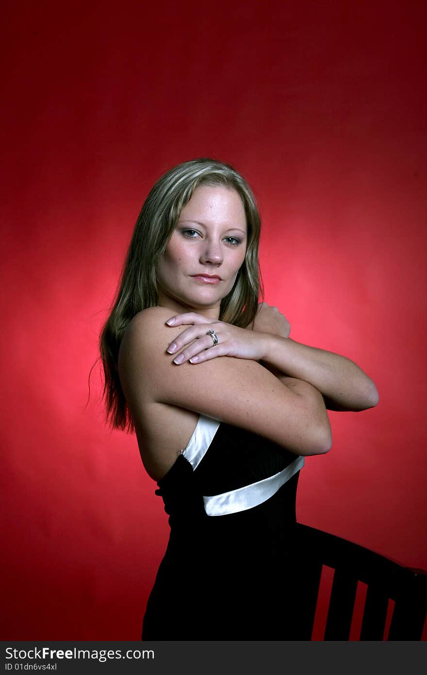 Sexy woman in black dress against red background