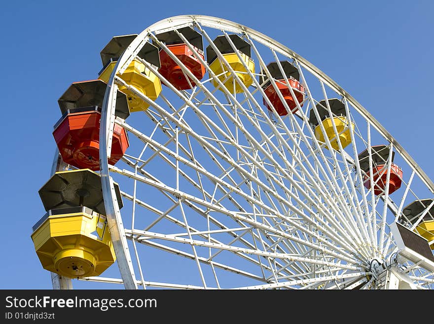 Ferriswheel in amustment park against sunny, blue sky.