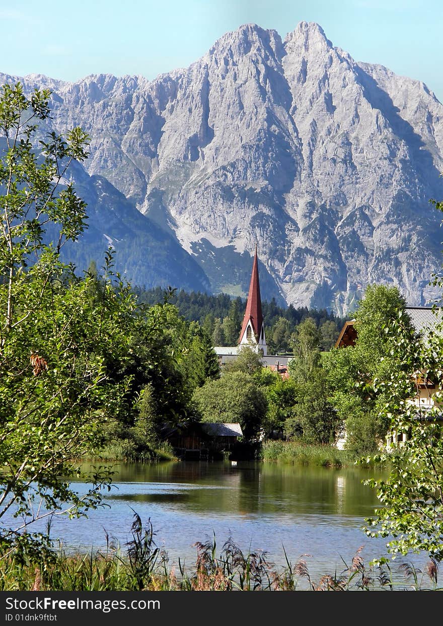 A landscape of tirolean mountain with a little lake and a church. A landscape of tirolean mountain with a little lake and a church.