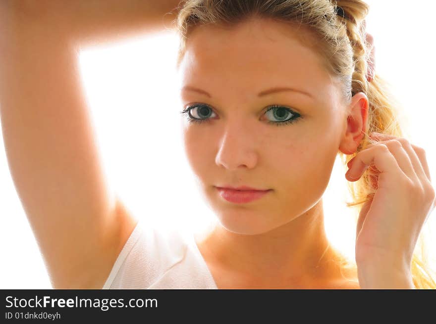 Head shot of model arranging her hair into a pony tail. Head shot of model arranging her hair into a pony tail