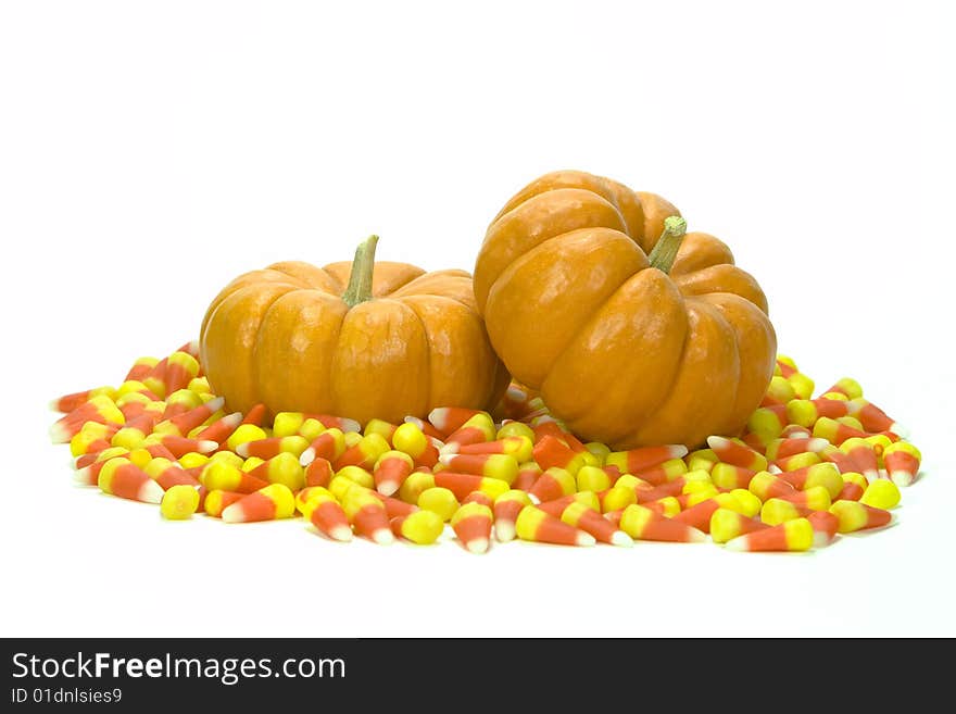 Two mini pumpkins in a field of candy corn. Two mini pumpkins in a field of candy corn.