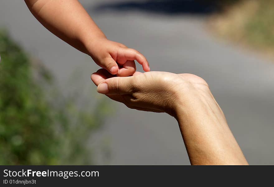 Baby is touching his mother's hand. Baby is touching his mother's hand