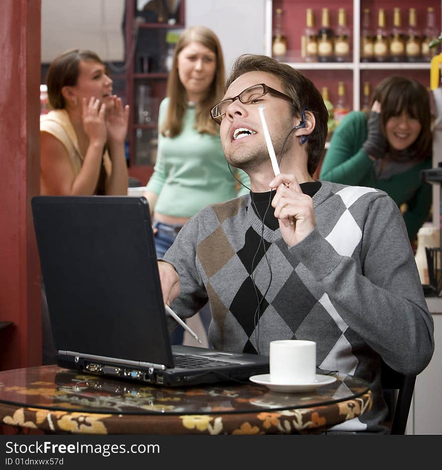 Obnoxious young man singing loudly in a coffee house