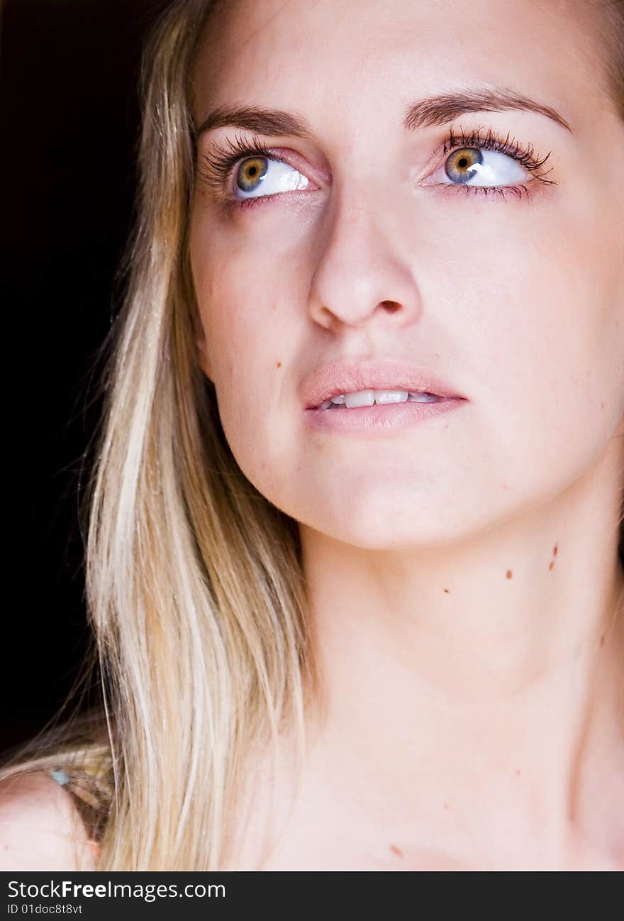 Blond praying woman against black background