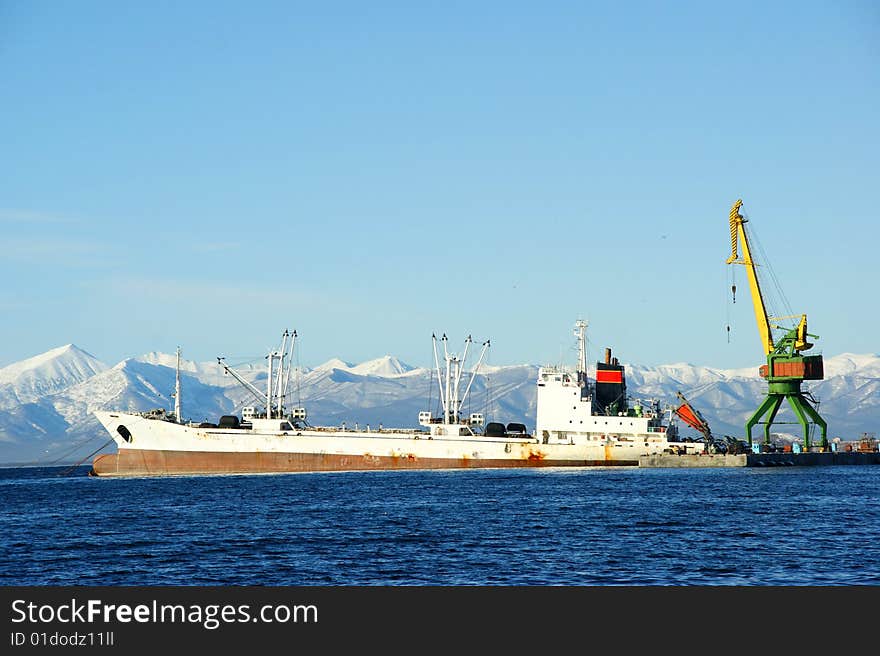 Tap loads ship on background of the mountains