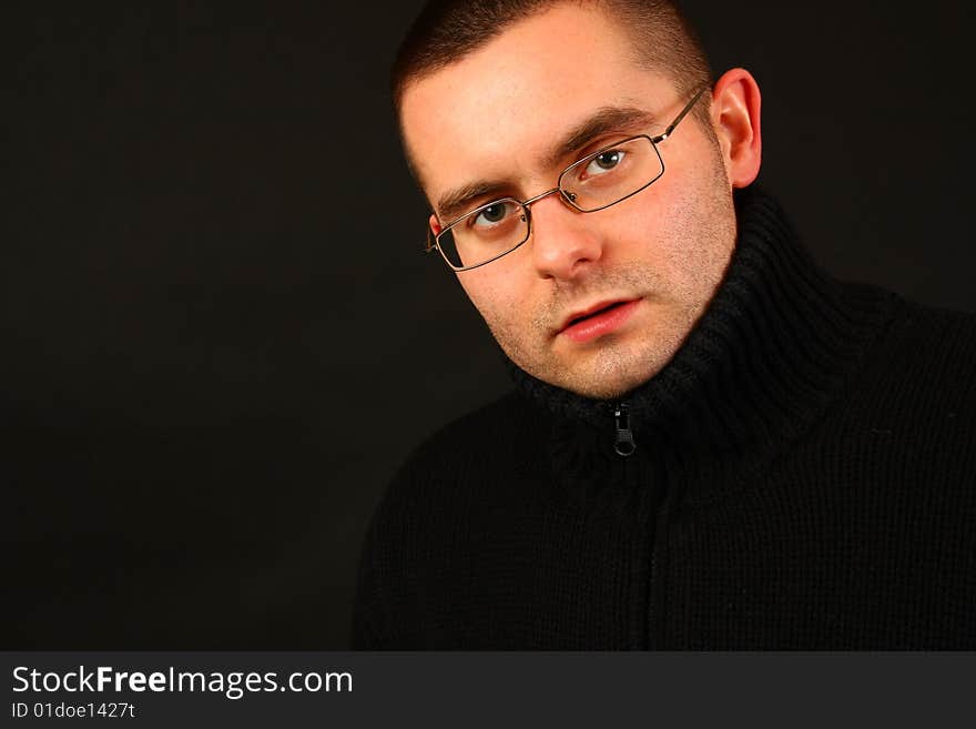 Young relaxed casual man on the dark background. Face portrait. Young relaxed casual man on the dark background. Face portrait