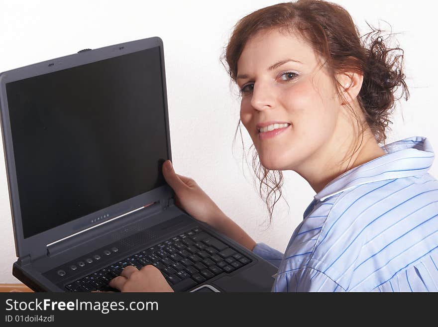 A young woman at home with her laptop. A young woman at home with her laptop.