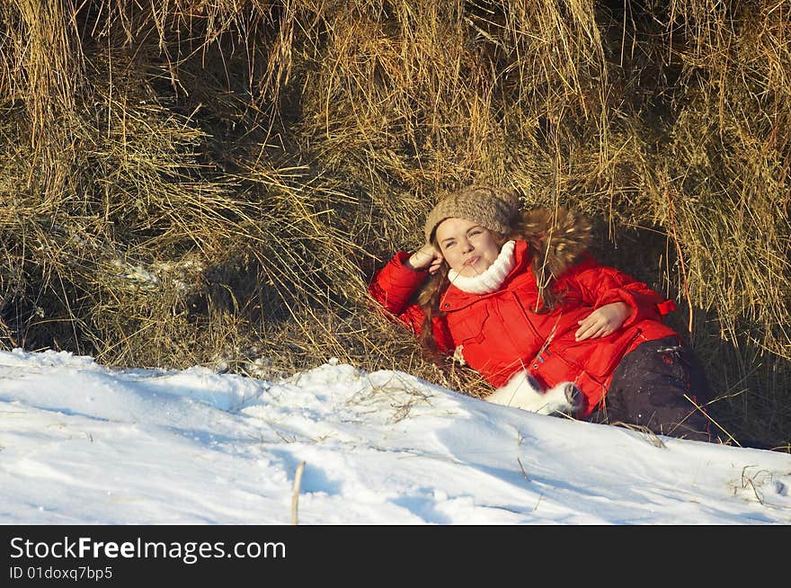 The girl in winter clothes sits about stacks. The girl in winter clothes sits about stacks