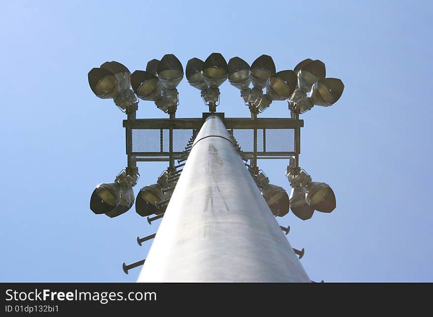 Stadium-style lights, taken at sports fields at a park, looking up, clear blue sky background, daytime so the lights are off. Stadium-style lights, taken at sports fields at a park, looking up, clear blue sky background, daytime so the lights are off.