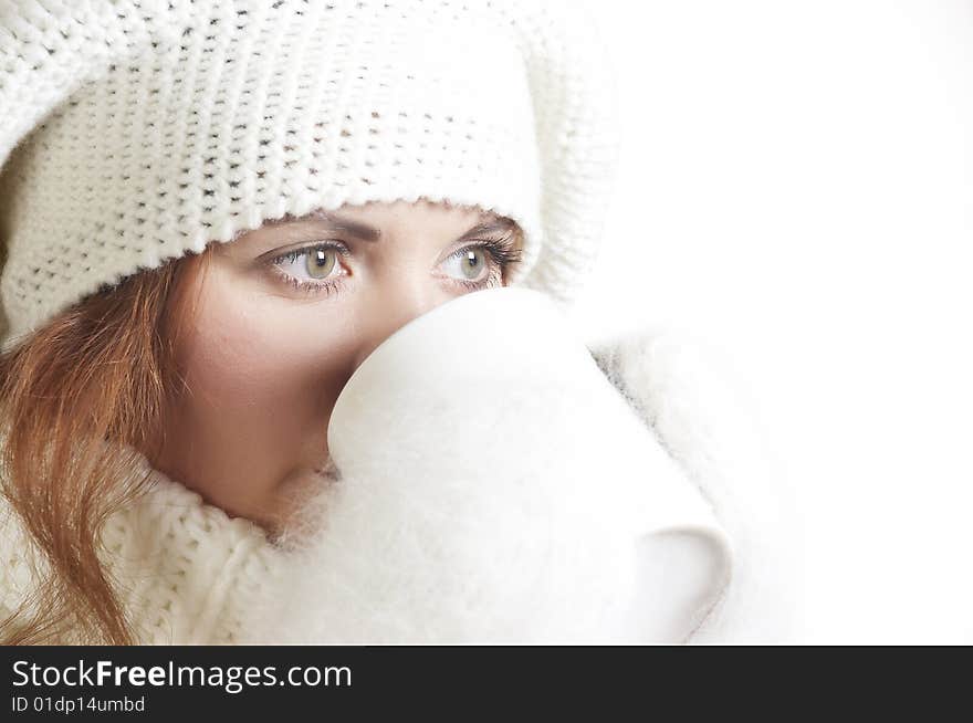 The beautiful young woman in a white sweater and winter cap. The beautiful young woman in a white sweater and winter cap