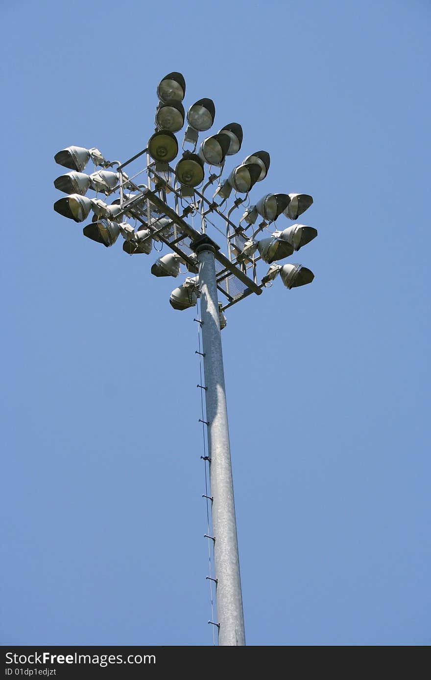 Stadium-style lights, taken at sports fields at a park, looking up, clear blue sky background, daytime so the lights are off. Stadium-style lights, taken at sports fields at a park, looking up, clear blue sky background, daytime so the lights are off.