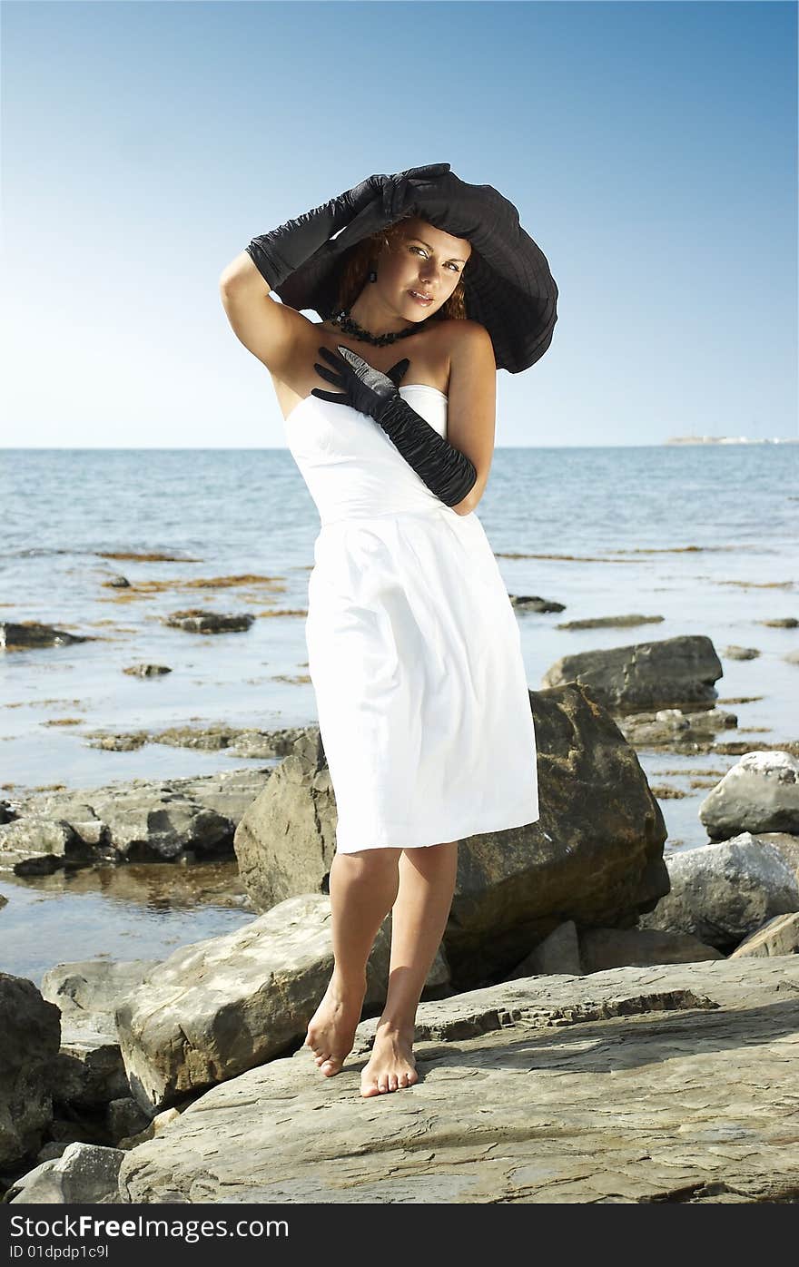 Portrait the woman in a hat on a coast of the sea