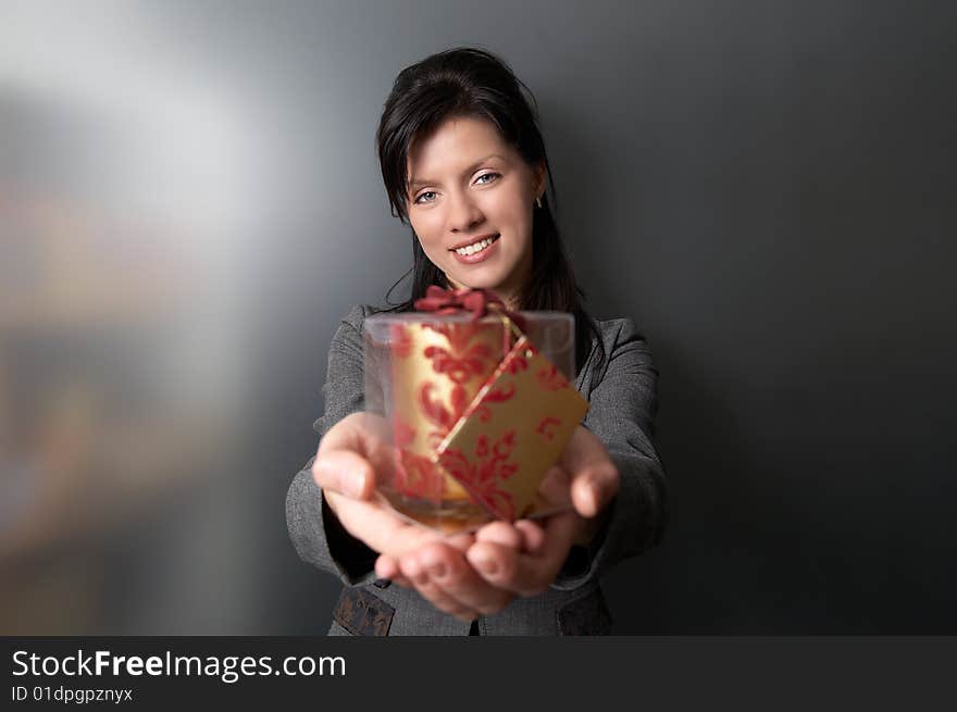 Young pretty caucasian woman is holding a red present. Young pretty caucasian woman is holding a red present