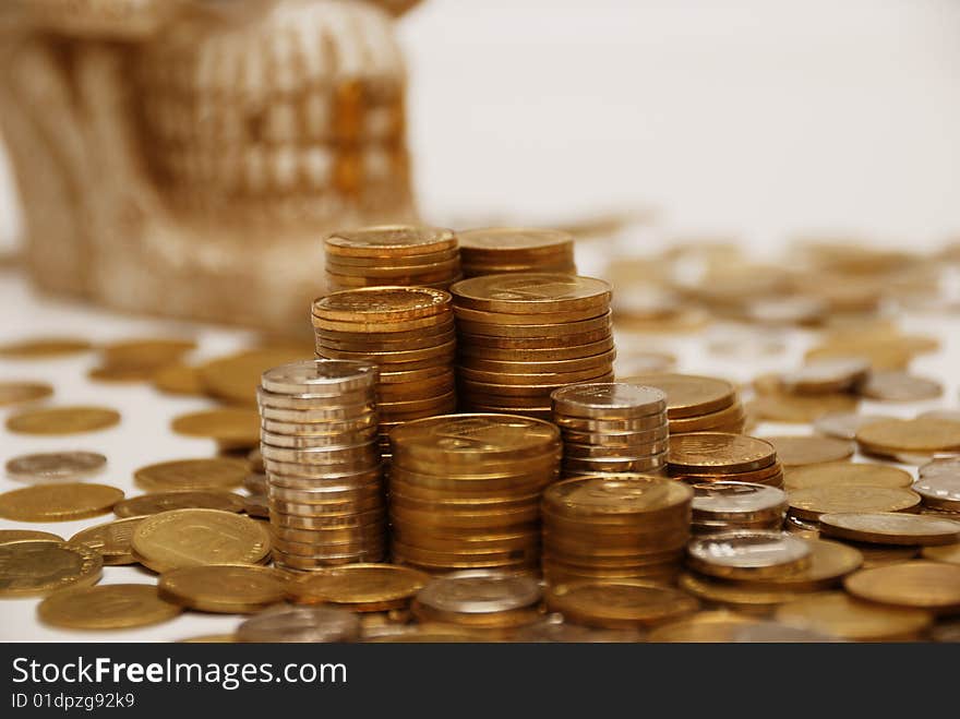 Different coins stacked and skull on a background. Different coins stacked and skull on a background