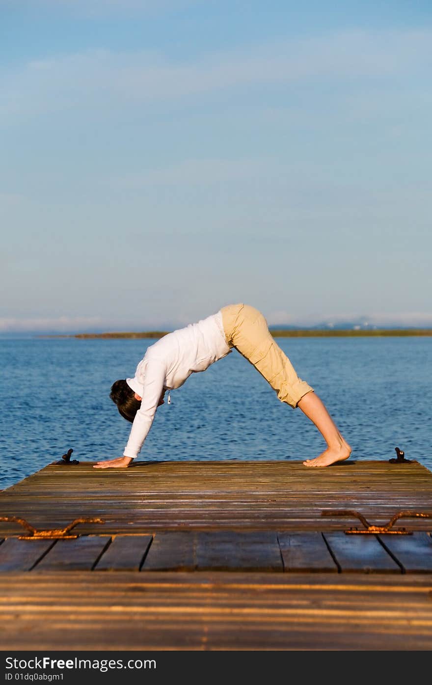 Yoga Woman on a dock by the ocean