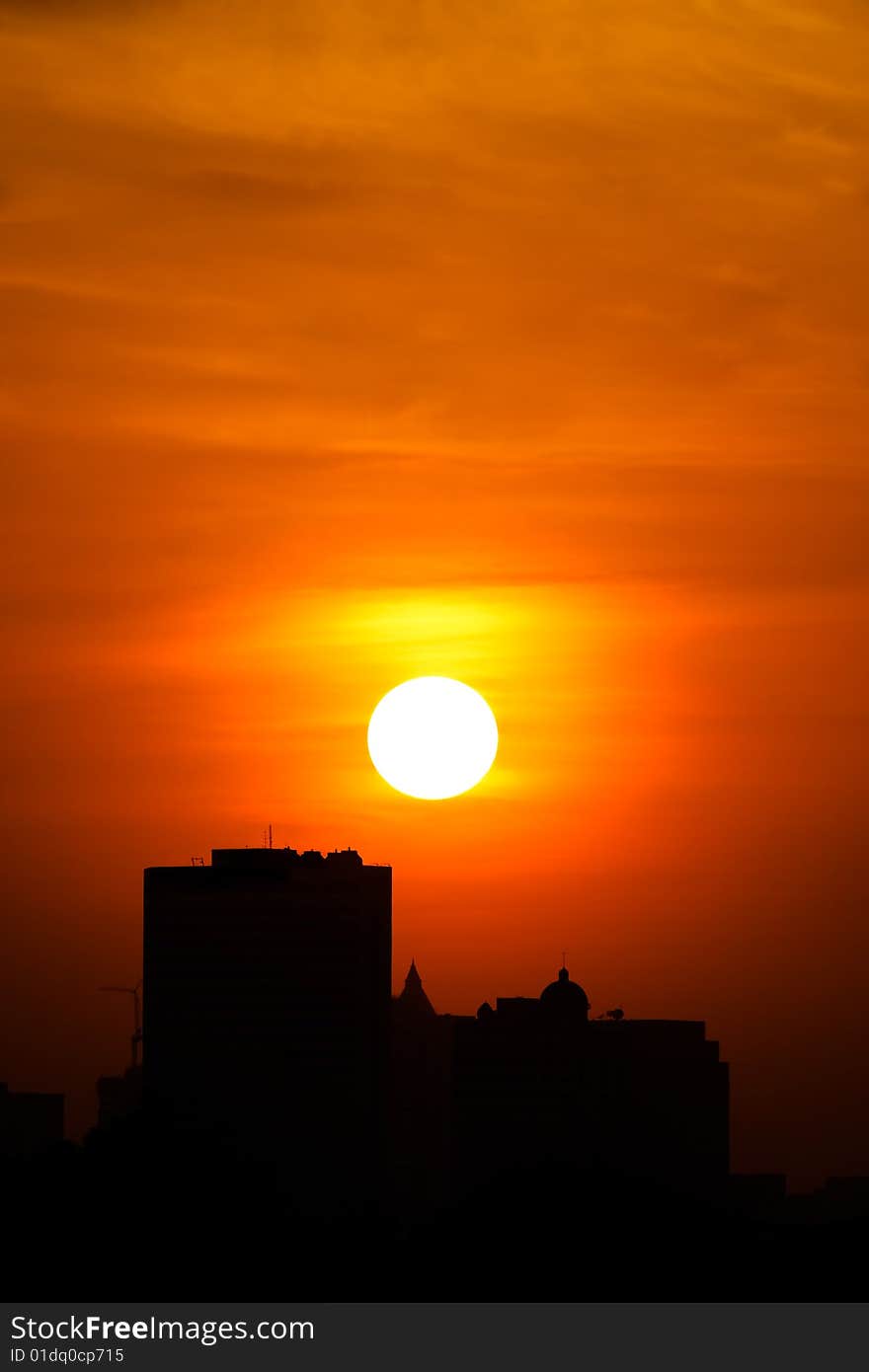 Picture of buildings with sun setting in the background. Picture of buildings with sun setting in the background.