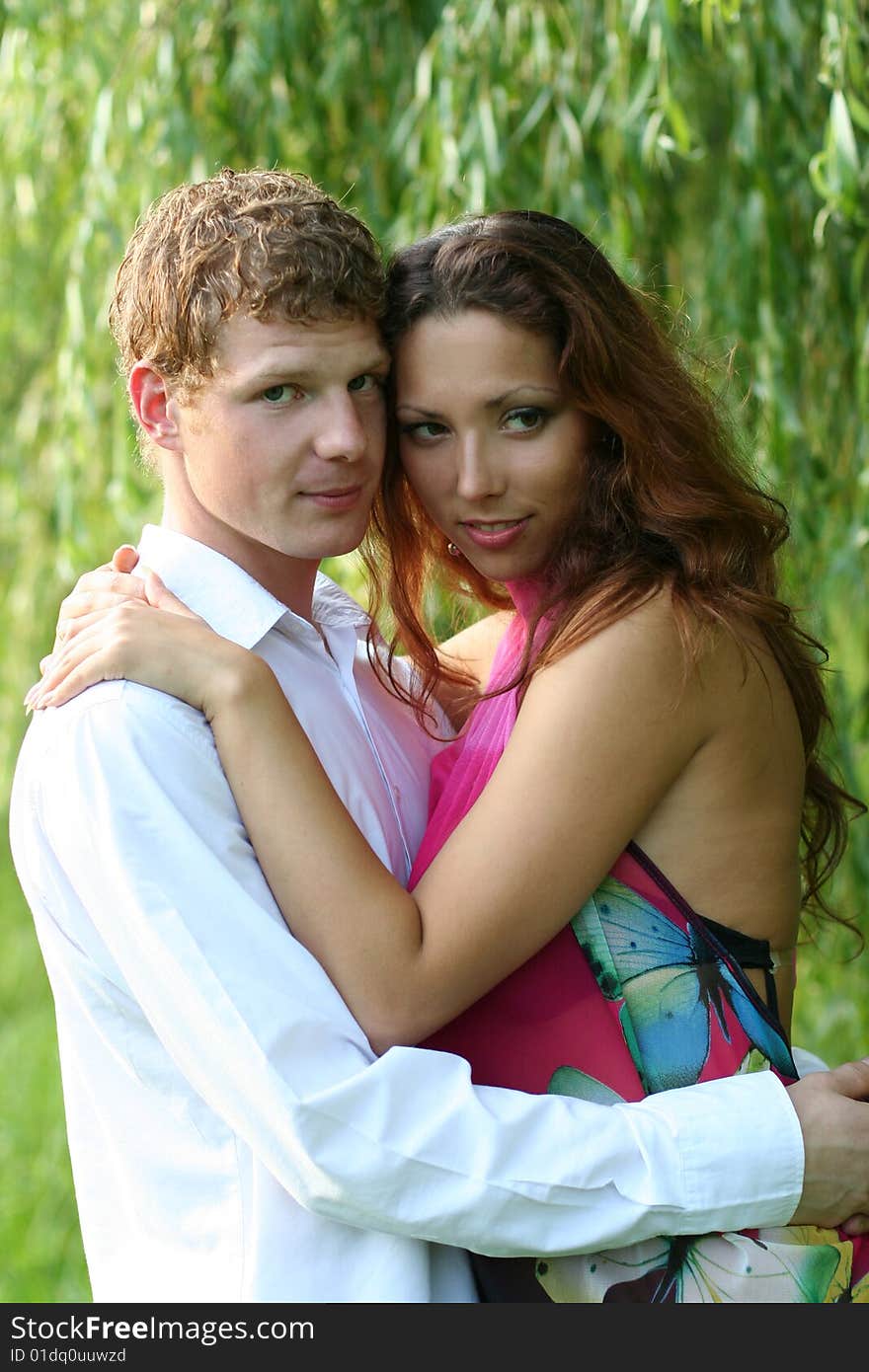 Cute young couple under green willow. Cute young couple under green willow