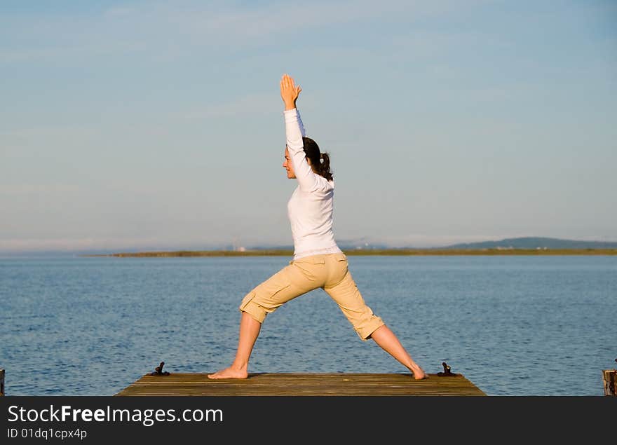 Yoga Woman on a dock by the ocean