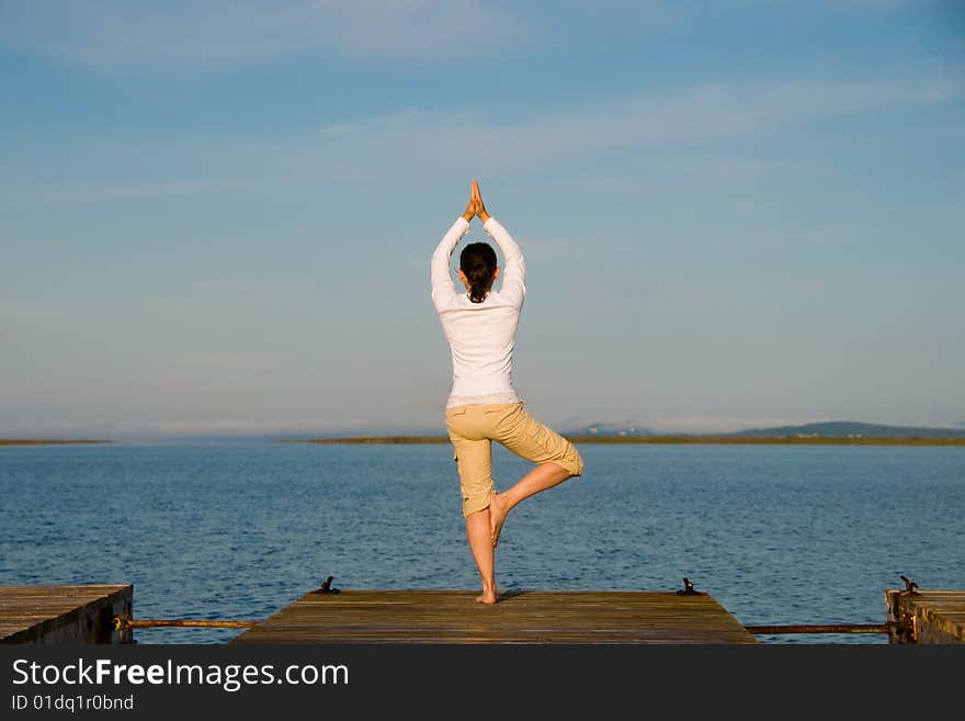 Yoga Woman on a dock by the ocean