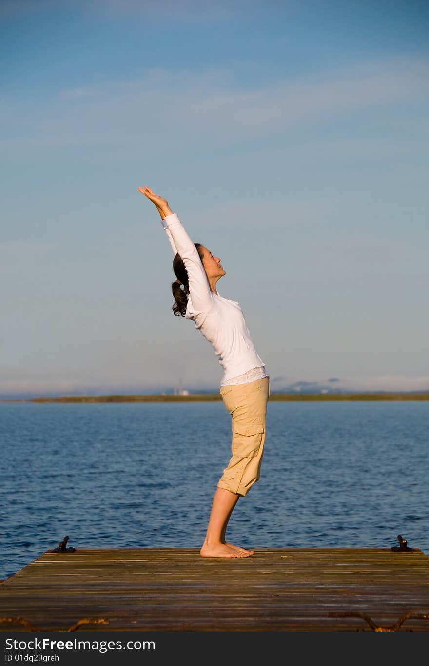 Yoga Woman on a dock by the ocean