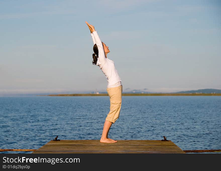 Yoga Woman on a dock by the ocean