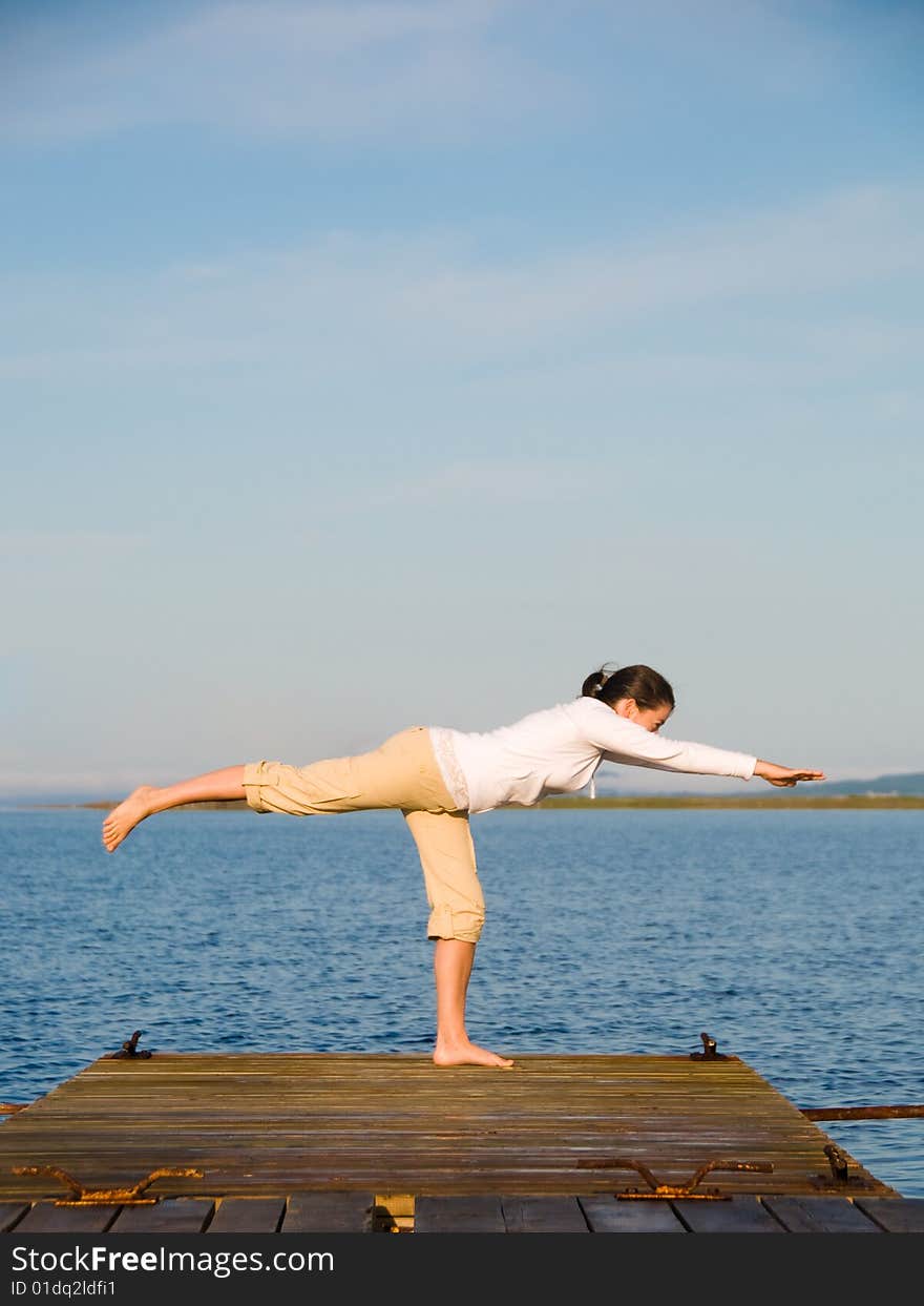 Yoga Woman on a dock by the ocean