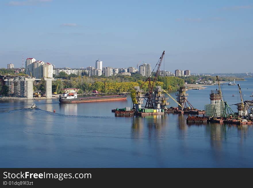 Building of new bridge across the river. River. Sun day. City. Autumn. Building of new bridge across the river. River. Sun day. City. Autumn.