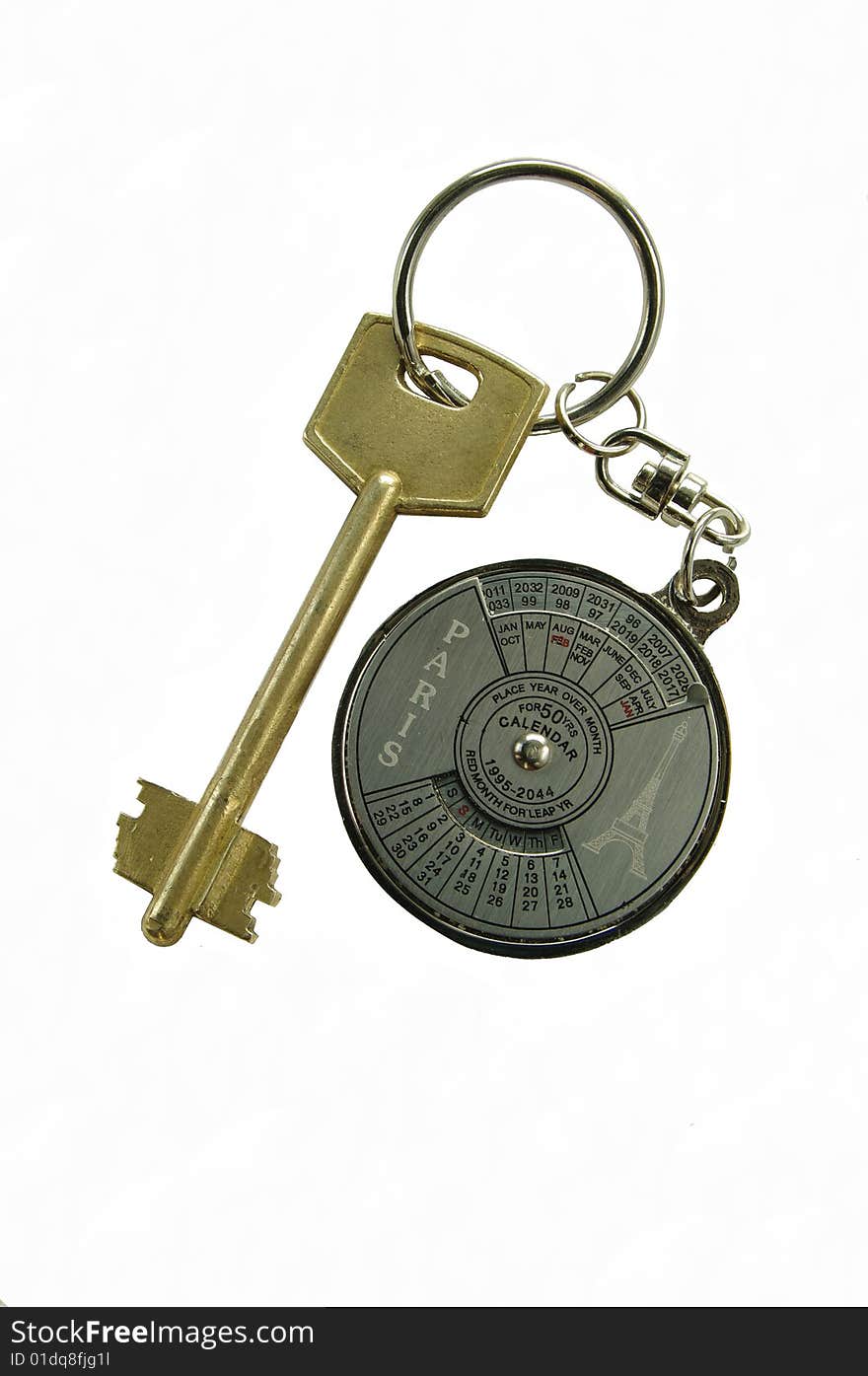 Key with a round, metallic trinket. On a trinket a calendar is represented. Key from a house.