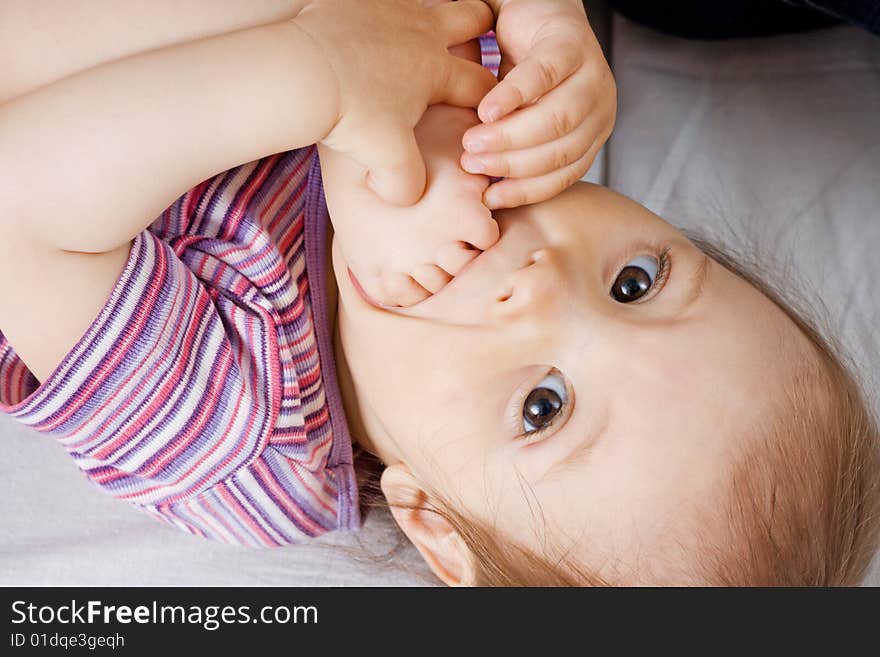 Small baby with its leg in mouth