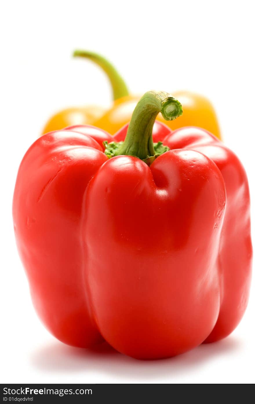 Red pepper isolated on a white background. In the background a yellow pepper. He blurred.