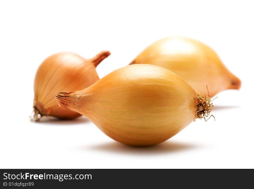 Three onions are on a white background. Background blurred. Isolated.