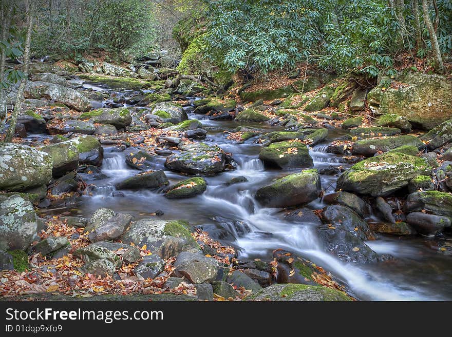 Beautiful mountain stream flowing through the mountain during fall.