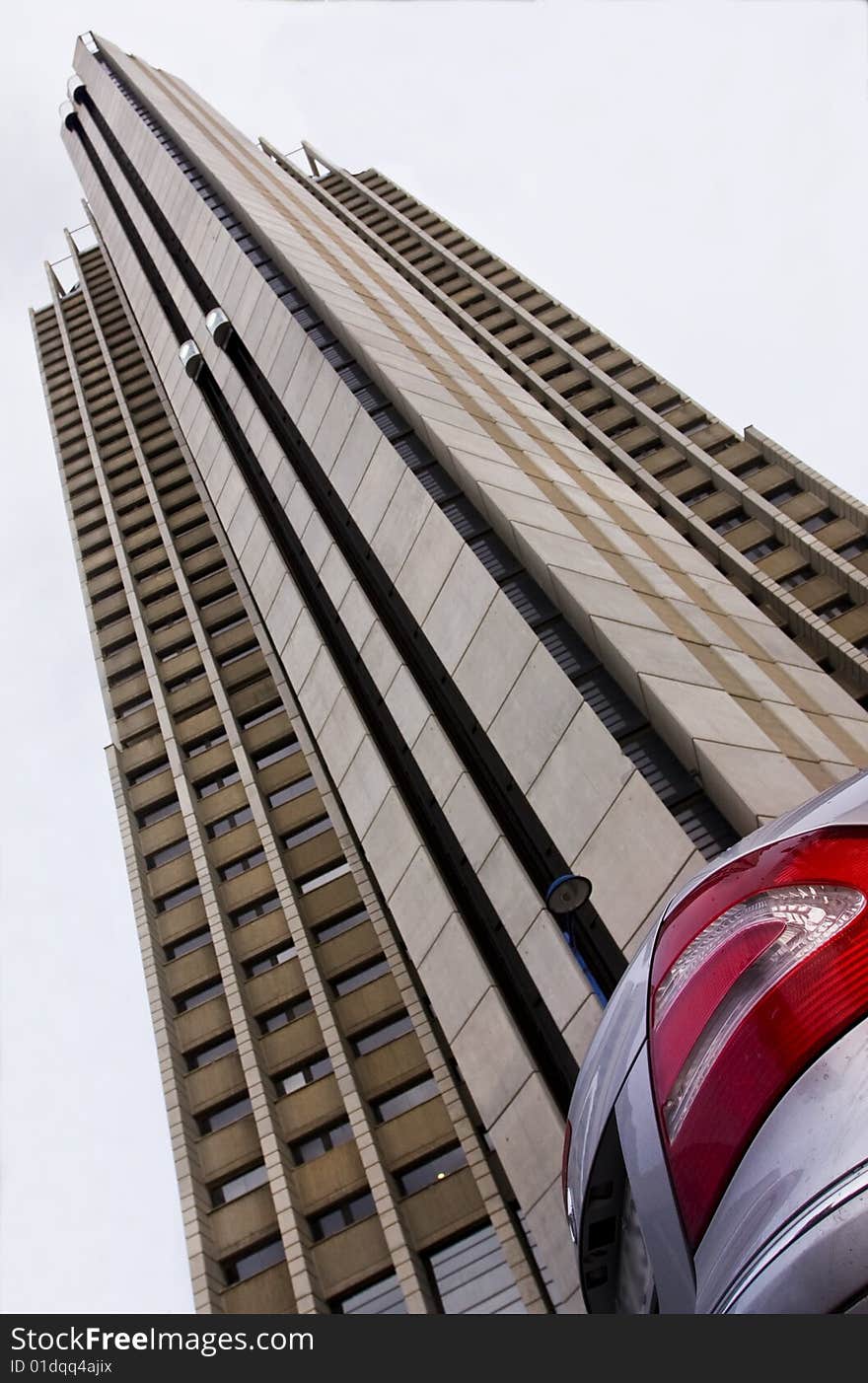 Vehicle corner parked in front of high building. Focus on car. Vehicle corner parked in front of high building. Focus on car.