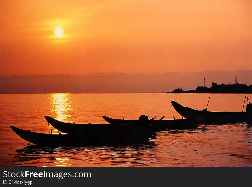 The fisher\'s small boats are casted in the sunset orange color in Taipei, Taiwan. The fisher\'s small boats are casted in the sunset orange color in Taipei, Taiwan.