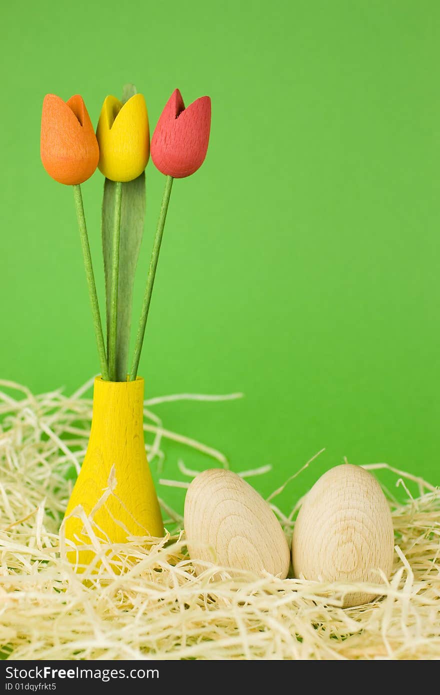 Wooden easter eggs with red, yellow and orange wooden tulips decoration.