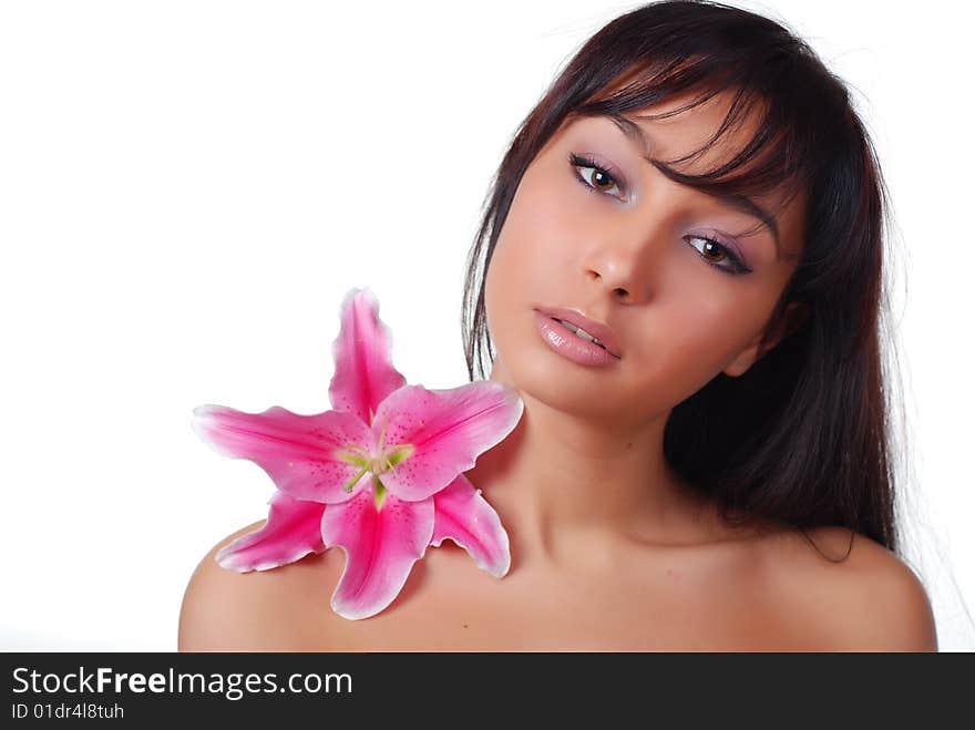 Portrait of young woman with lily on her shoulder