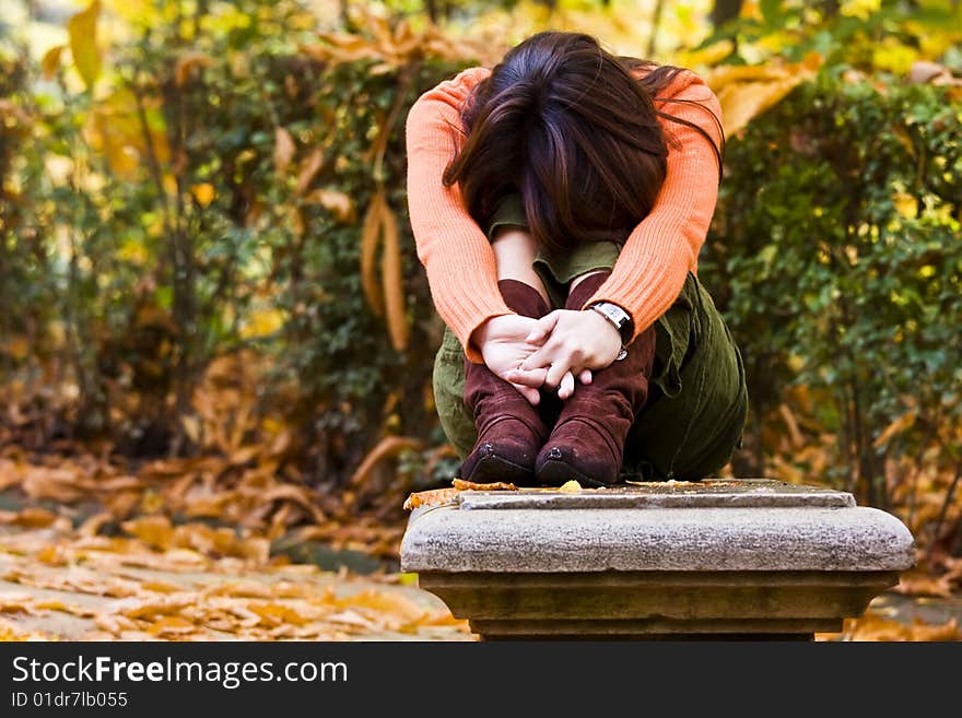 Young woman sitting between autumn colors. Young woman sitting between autumn colors.