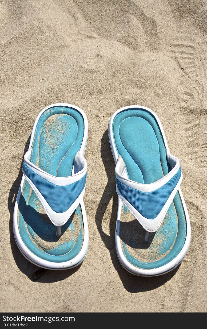 A pair of blue sandals on the beach