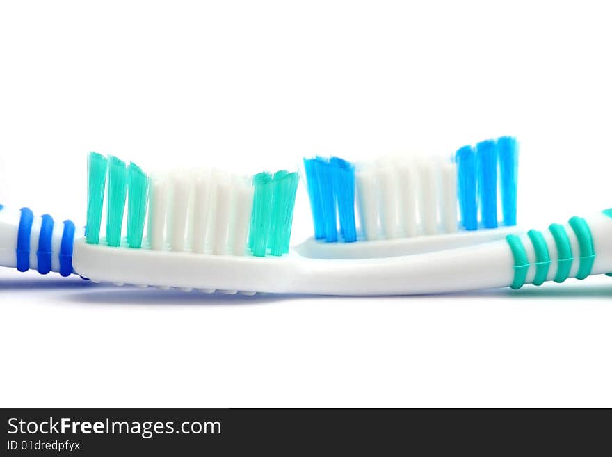 Close up of two tooth brushes on white background.