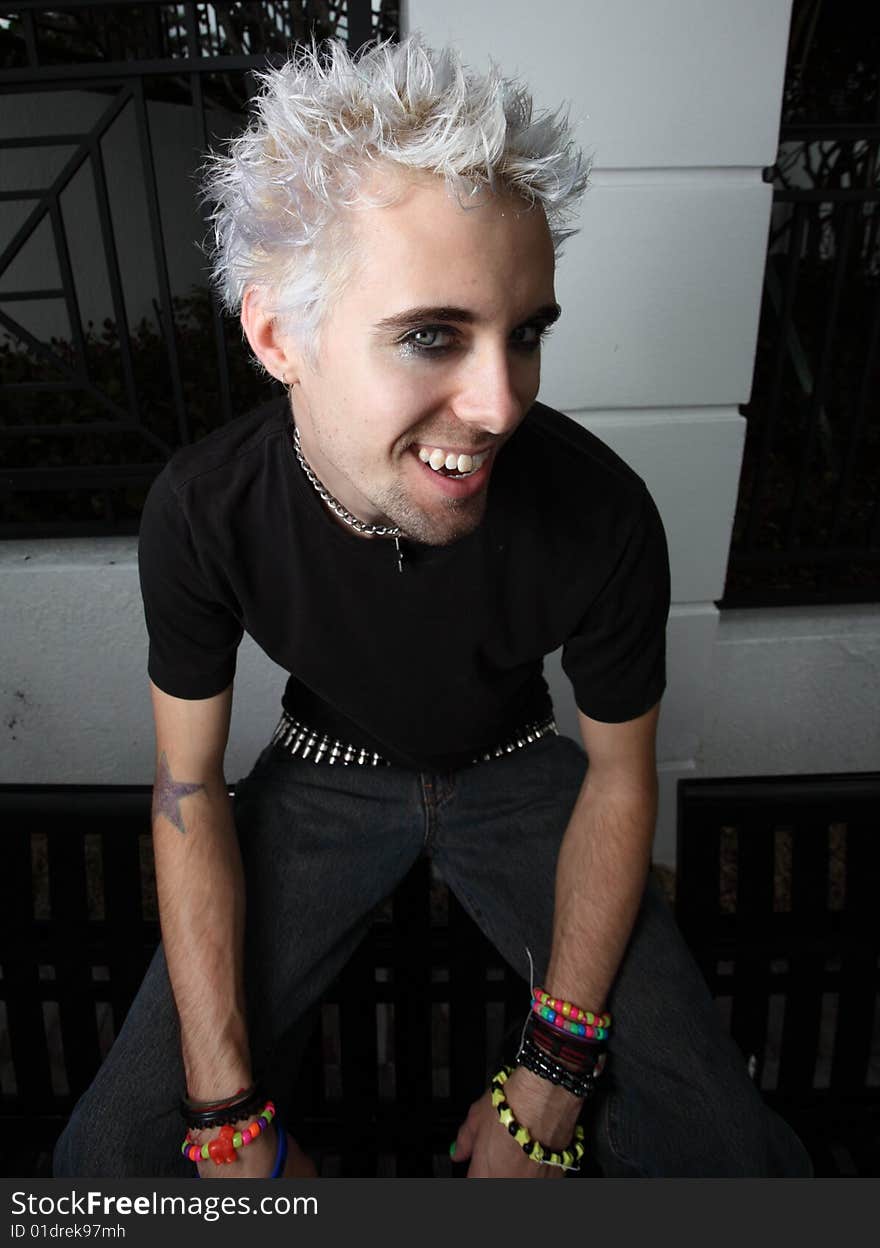 Young man with bleached hair looking upward with a smile. Young man with bleached hair looking upward with a smile