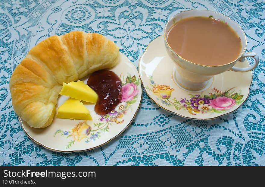 Tea and fresh croissant with jam and butter. Tea and fresh croissant with jam and butter