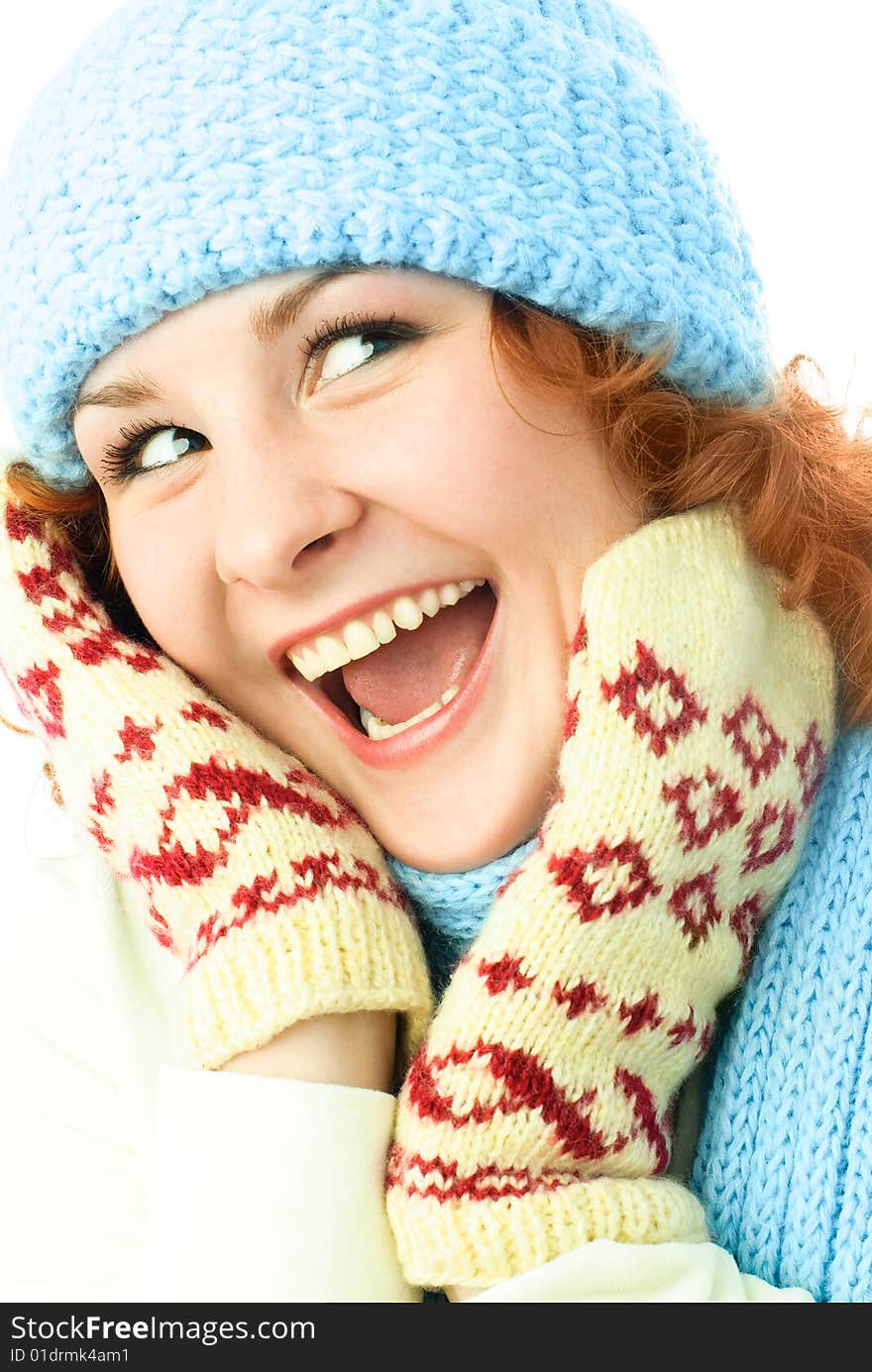 Happy excited ginger girl wearing a warm blue hat, mittens and scarf. Happy excited ginger girl wearing a warm blue hat, mittens and scarf